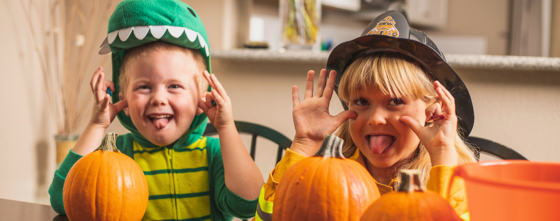 Children making silly faces at home dressed in Halloween Costumes